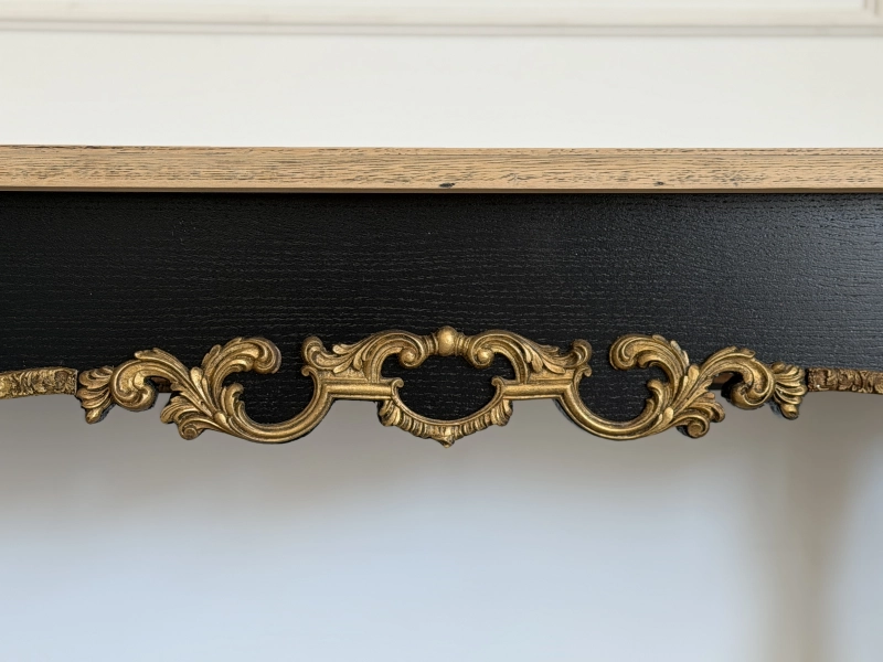 Close-up of handcrafted gilded ornament detail on Aurelia luxury console table.